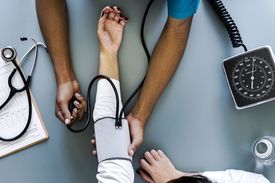 Healthcare: Nurse measuring patient blood pressure
